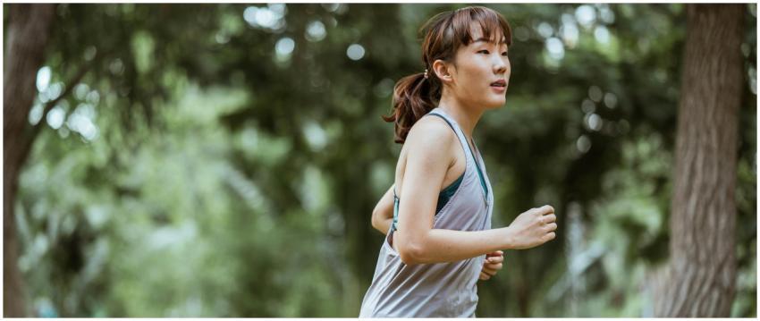 A young woman jogging with concentration through a