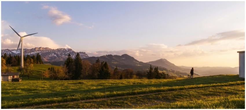 Wind turbine in Swiss landscape at sunset promotes