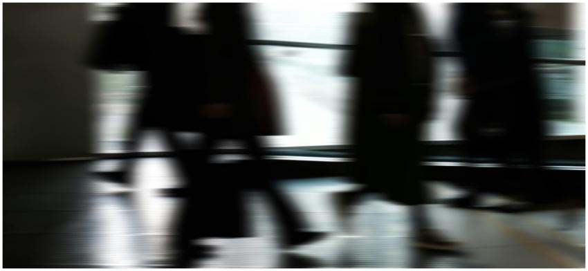 Abstract blurred motion of people walking indoors,
