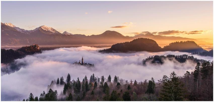 Majestic sunrise over misty mountains and forest,