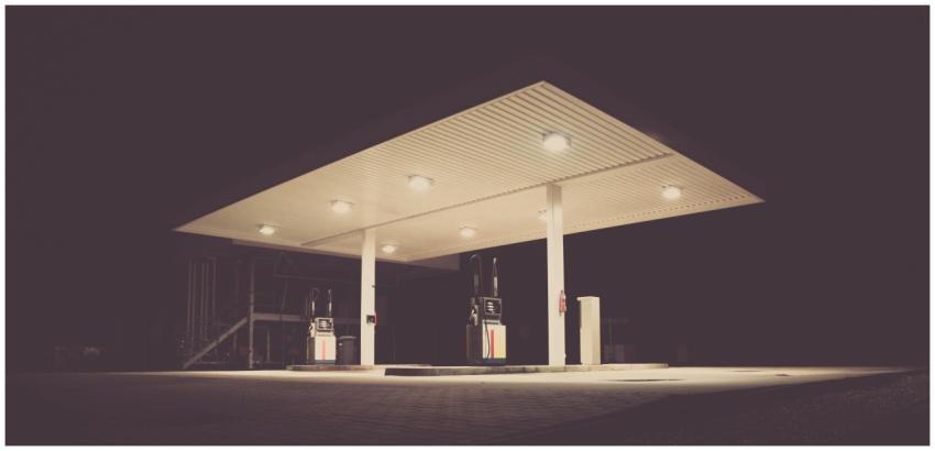 A dimly lit gas station at night, offering an eeri