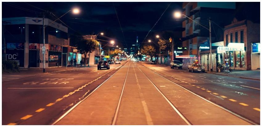 Street view of a bustling city at night with tram