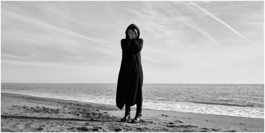 Black and white image of a person in long coat exp