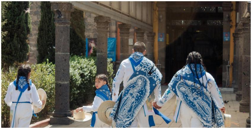 A family dressed in traditional attire walks throu