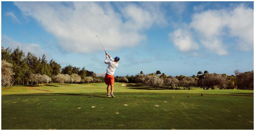 A golfer swings on a picturesque golf course with