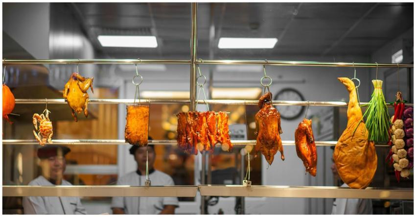 Vibrant market scene of hanging meats and vegetabl