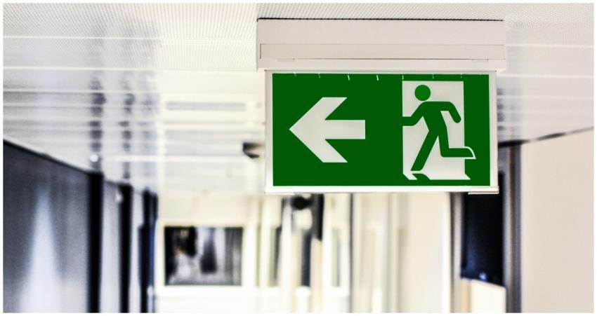 Green emergency exit sign with directional arrow i