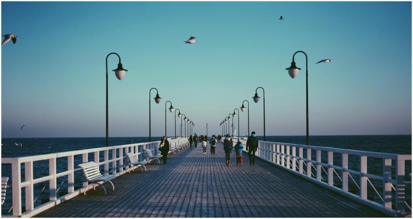 A peaceful pier in Gdynia, Poland with people stro