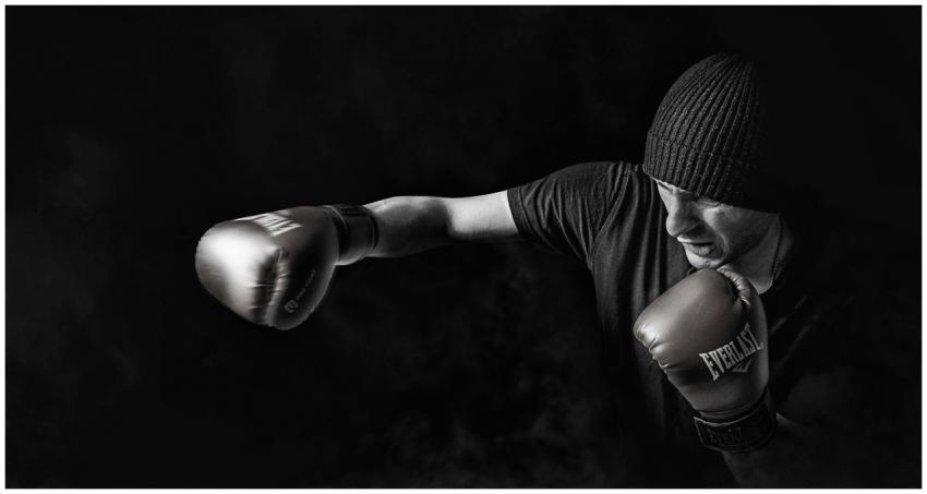 A powerful black and white image of a boxer throwi
