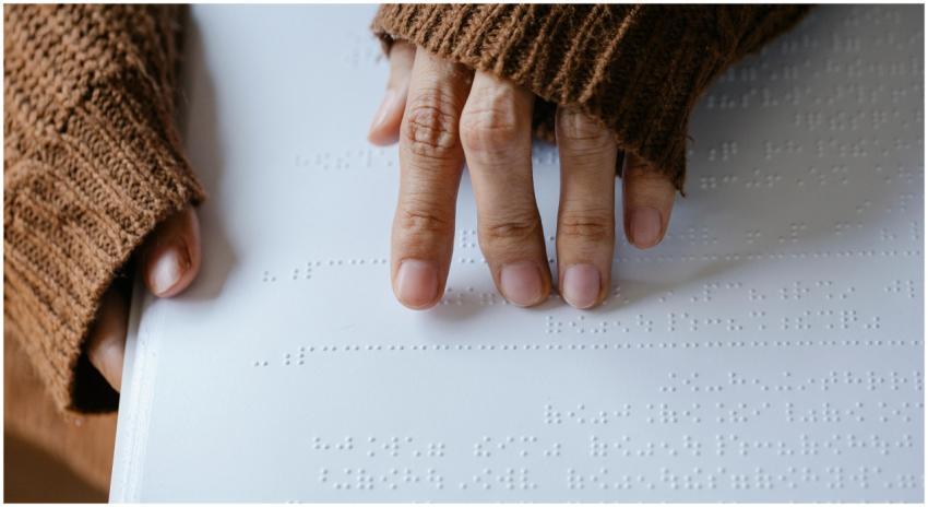 Close-up of hands in a knitted sweater reading bra