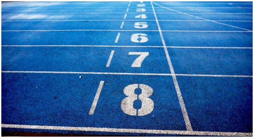 Blue athletic running track with numbered lanes, i