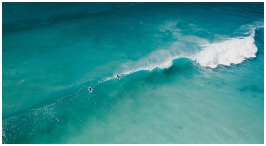 A breathtaking aerial view of surfers riding waves