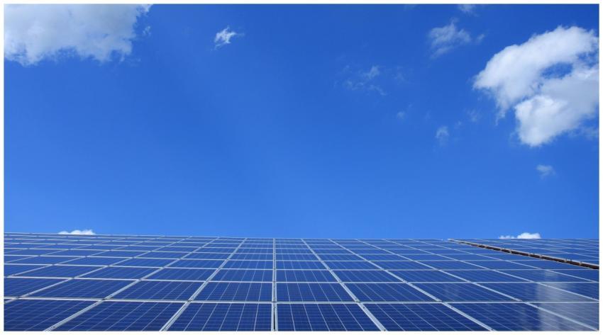 A low angle view of solar panels under a bright bl