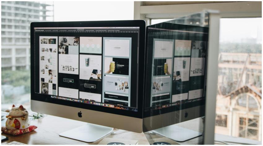 Dual monitors on a desk, showcasing web design in