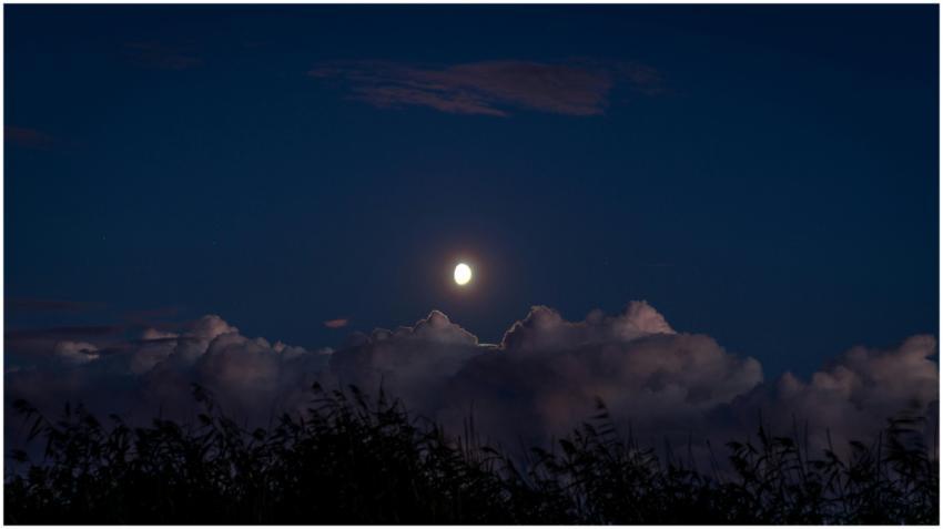 A tranquil night sky showcasing the moon illuminat
