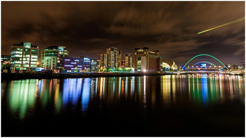 Vibrant city skyline at night reflecting on water