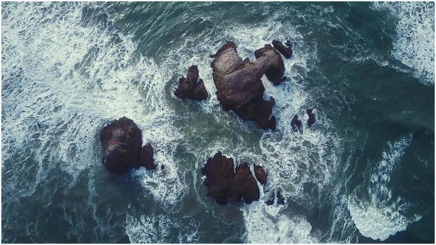 Dynamic aerial view of ocean waves crashing agains
