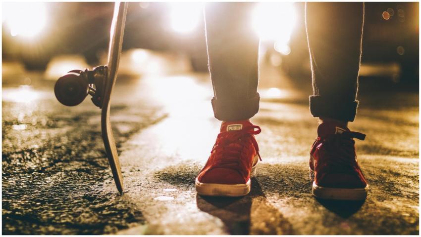 Close-up of a skateboarder in red sneakers standin