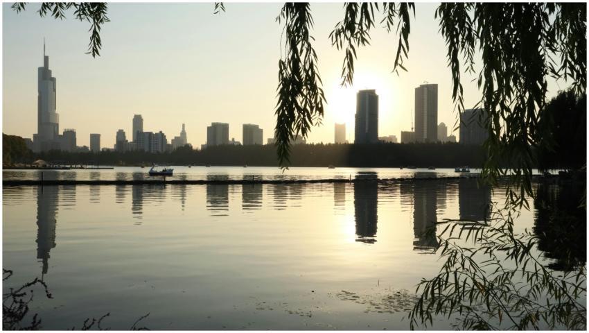 Cityscape with sunset reflections over water and s