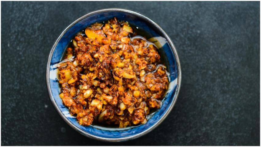A vibrant bowl of spicy chili oil with garlic and