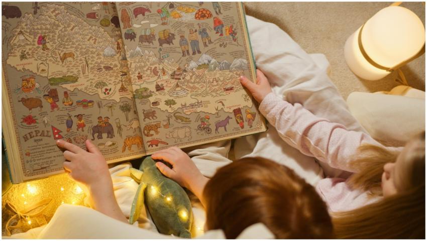 Two children exploring an illustrated atlas about