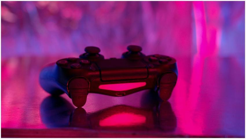 A wireless game controller in focus with a vibrant
