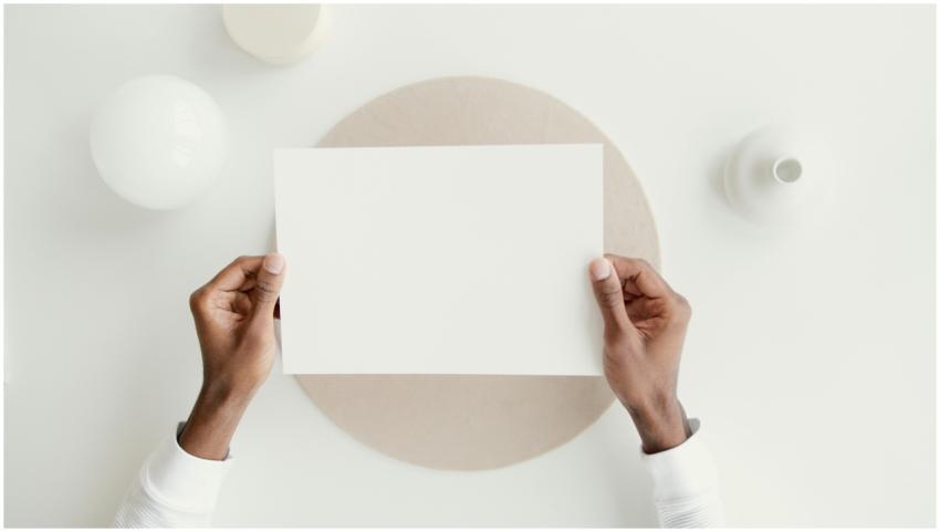 Minimalist mockup featuring hands holding blank pa