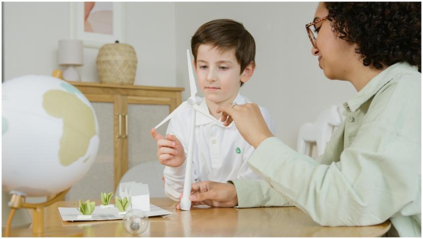 A boy and teacher exploring a wind turbine model,
