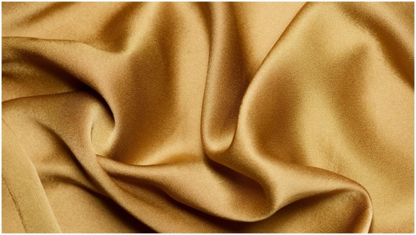 Luxurious close-up of gold silk fabric with elegan