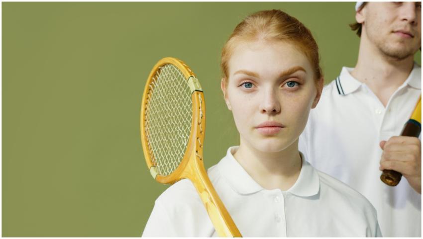 Young squash players posing with rackets against a