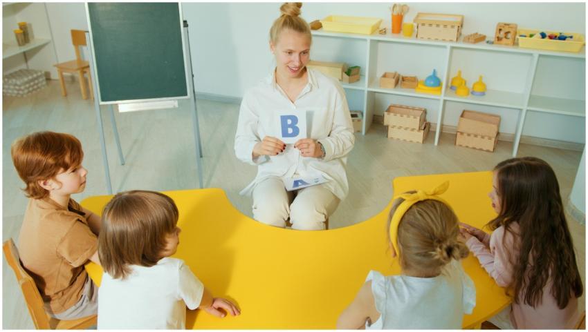 Teacher with children learning the alphabet in a v