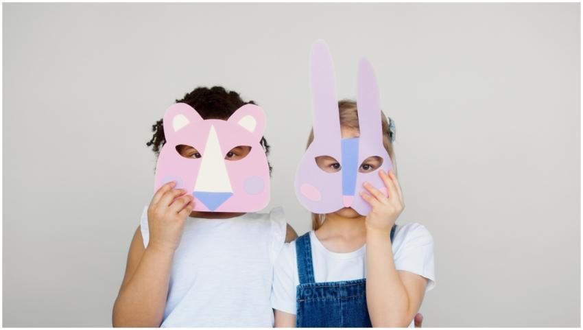 Two children wearing playful animal masks, showcas