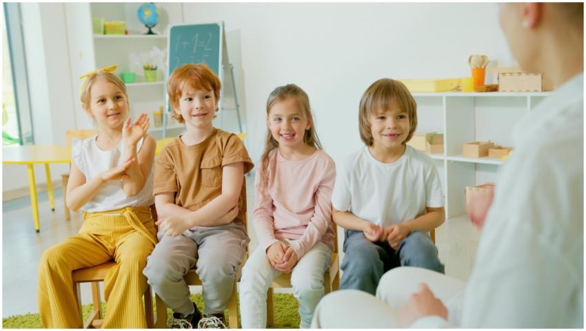 Group of cheerful children clapping hands in a liv