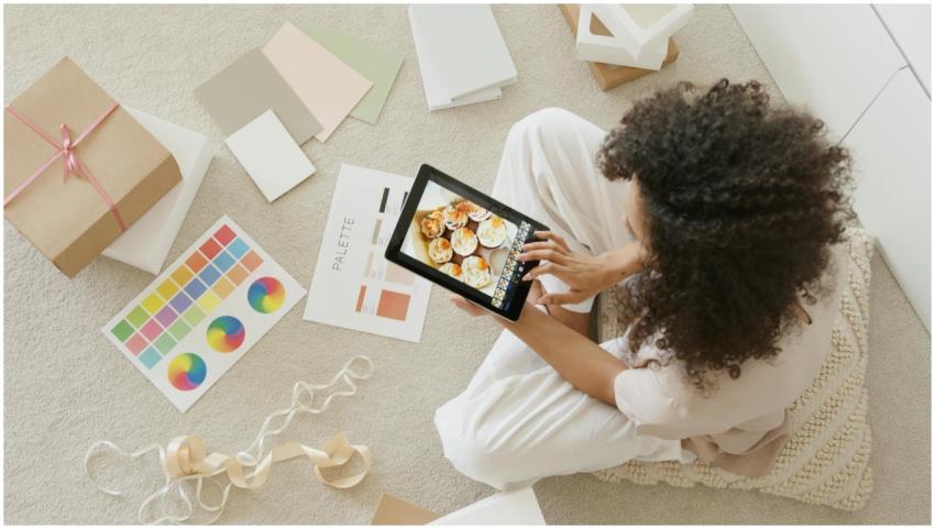 Woman using tablet surrounded by design tools and