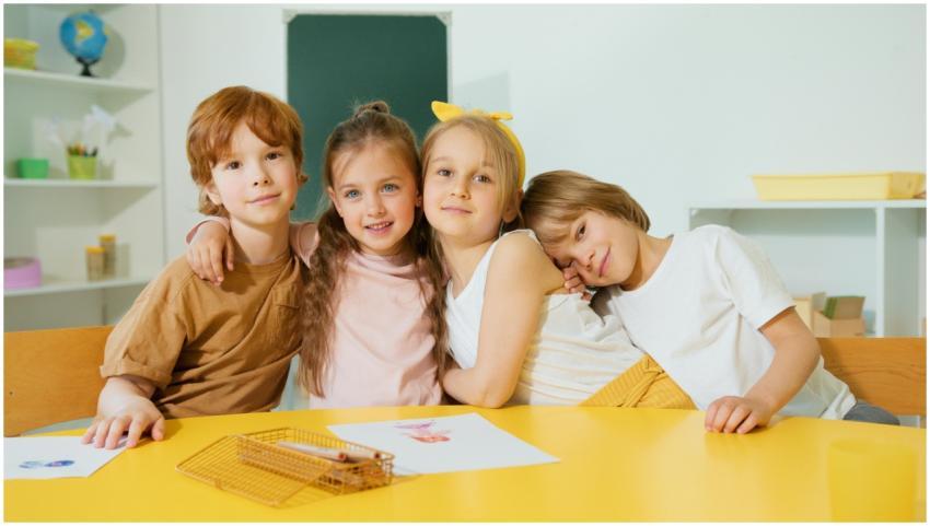 Smiling children sitting together at a colorful ta