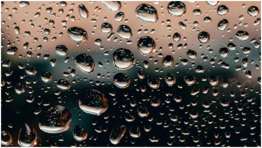 Macro shot of raindrops on a glass window with a c