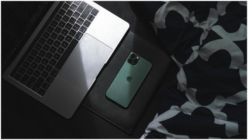 A sleek laptop and smartphone resting together. Id