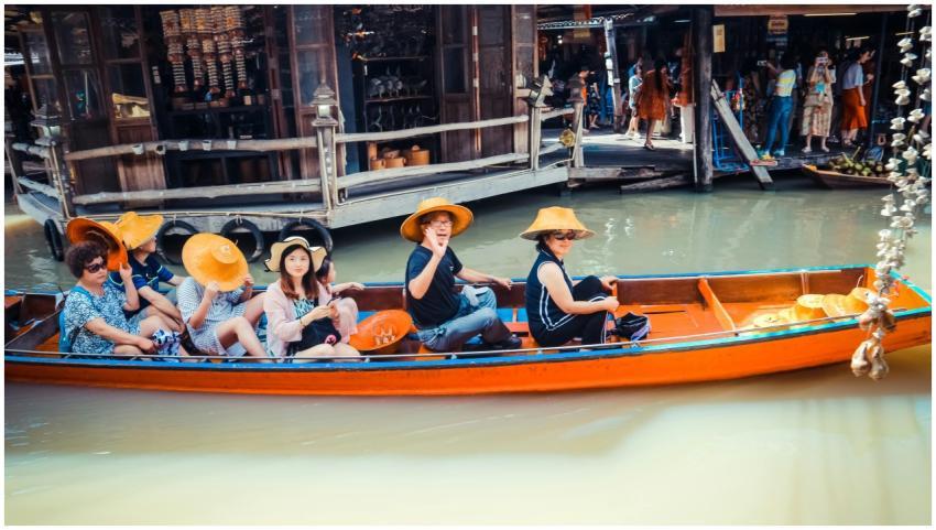 A group of tourists in a boat at a vibrant floatin