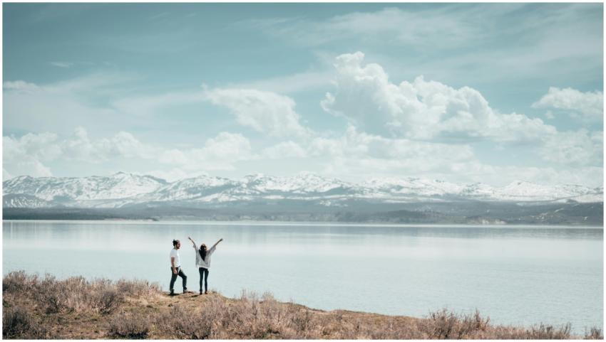 A couple with arms raised enjoys a stunning view o