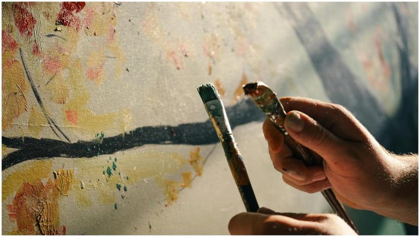 Close-up of hands painting abstract art on a canva