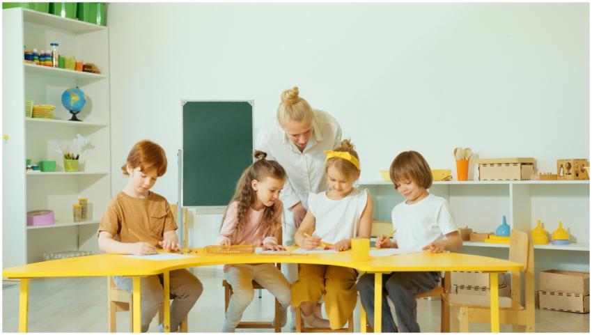 A teacher guides young students in a bright classr