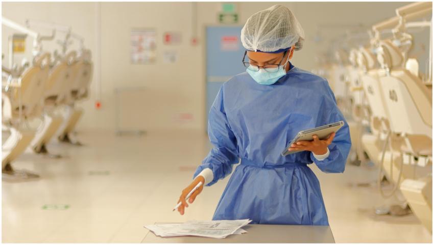 A healthcare professional in blue protective gear