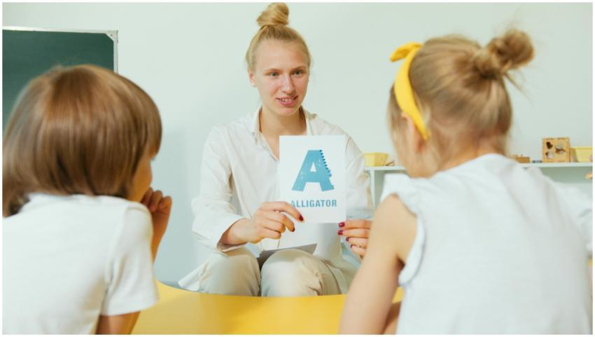 A teacher showing alligator-themed alphabet cards