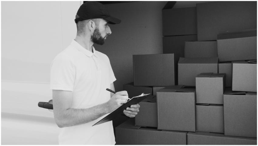A delivery man inspecting cardboard boxes in a van