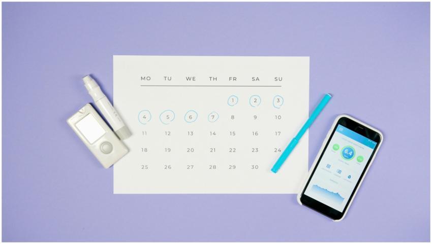 Flat lay of calendar with medical devices and smar