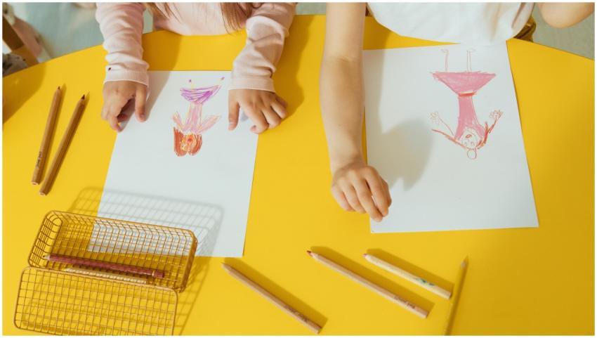 Two children drawing colorful pictures with crayon