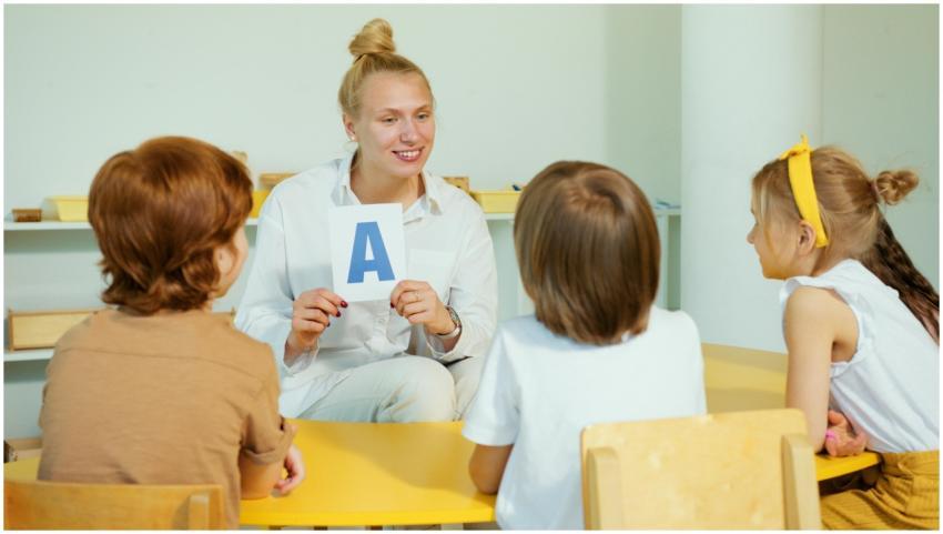 A teacher holds up a letter card while interacting