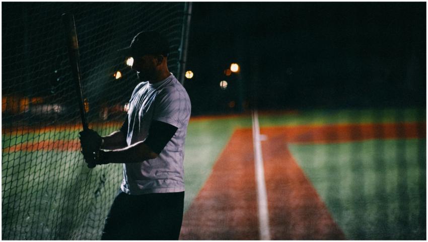 Silhouette of baseball player practicing batting a