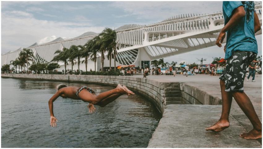 African American boy dives into water near the Mus
