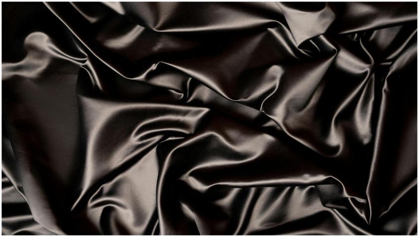 Close-up of luxurious black silk fabric with a smo